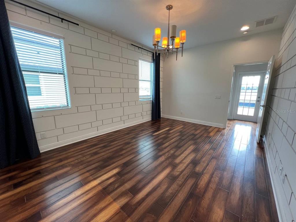 1692 Nature View Drive Lutz, FL 33558 - Photo 15 of 53 an empty room with wooden floor chandelier and windows