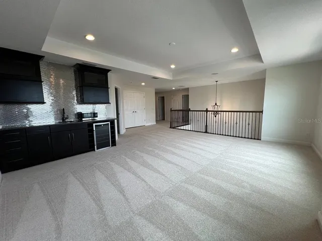 a view of an empty room with a window and cabinet