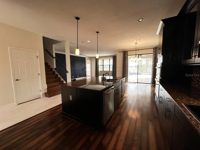 a kitchen with wooden floor window and stainless steel appliances