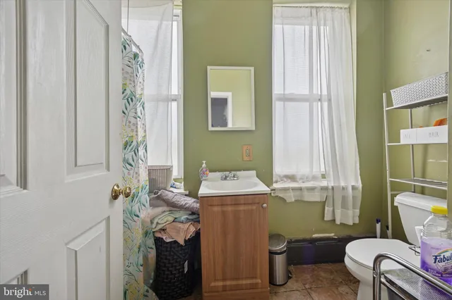 a bathroom with a sink toilet and window