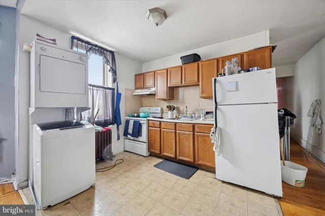 a kitchen with a refrigerator a stove top oven a counter space and a window