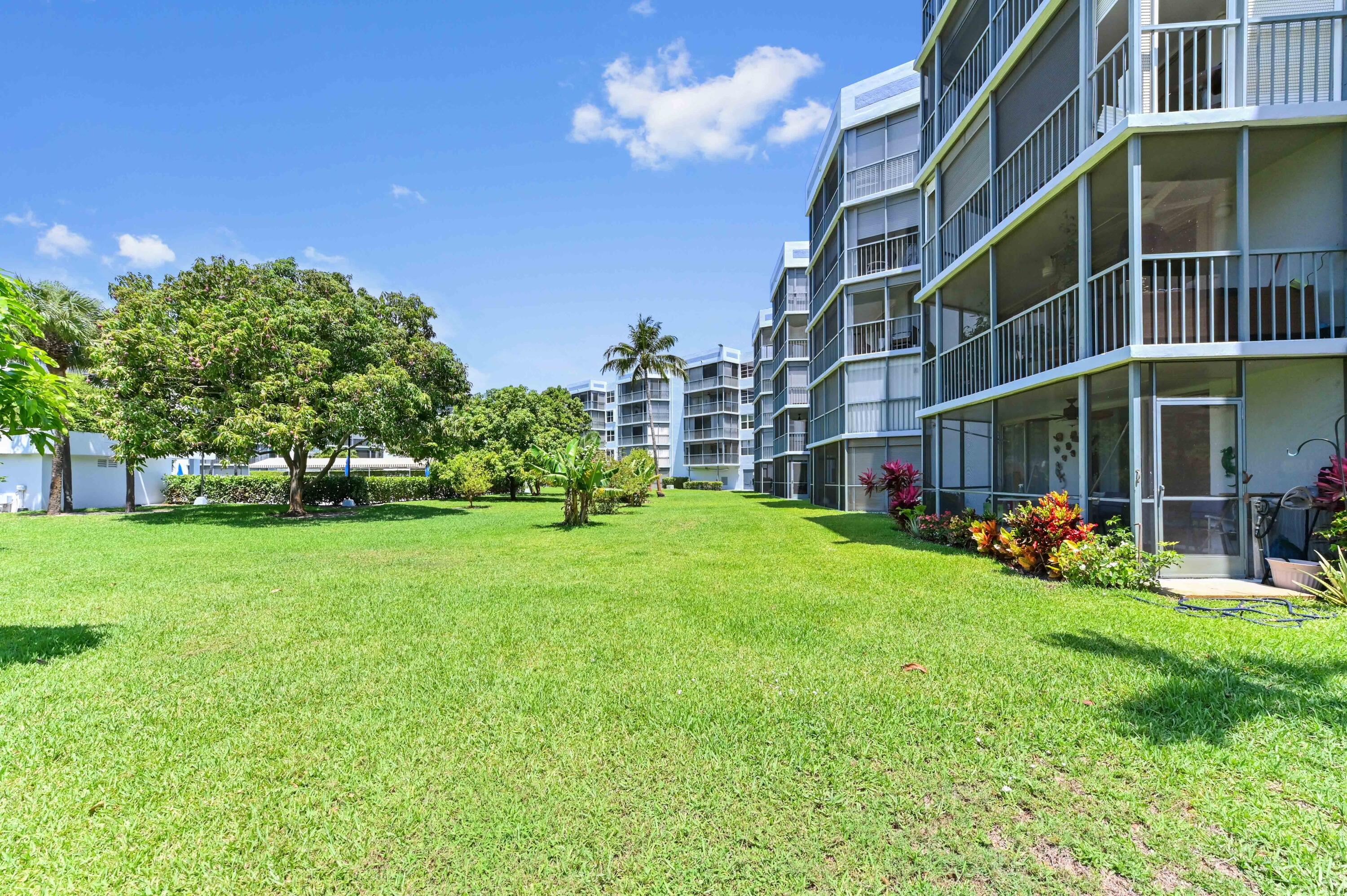 198 Northwest 67th Street, Unit 207 Boca Raton, FL 33487 - Photo 38 of 42 a view of a building with a yard