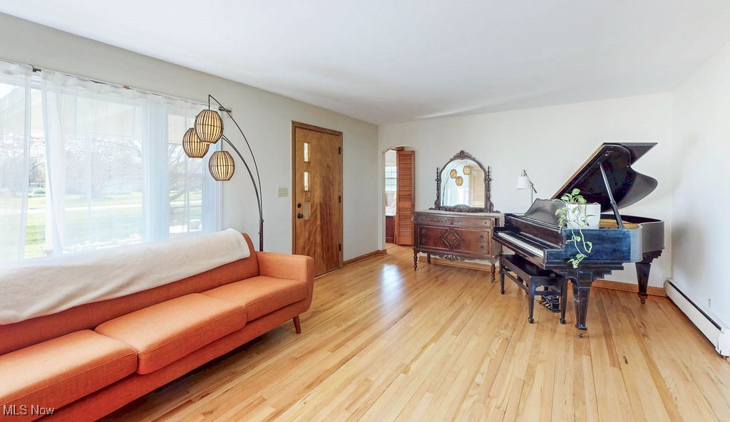 3464 South Bailey Road North Jackson, OH 44451 - Photo 11 of 33 Living room with arched walkways, light hardwood flooring, and a baseboard radiator