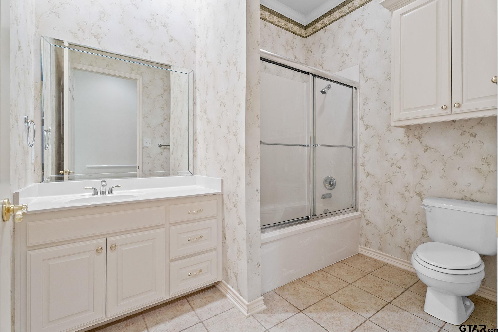 2438 Dietz Lane Tyler, TX 75701 - Photo 19 of 26 a bathroom with a toilet a sink a mirror and vanity