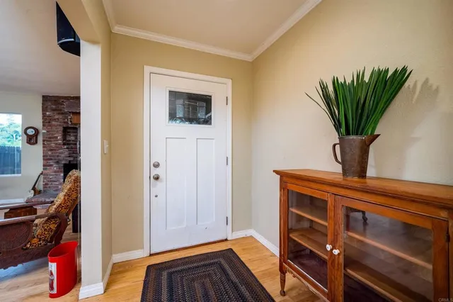 a view of a hallway with wooden floor and a potted plant