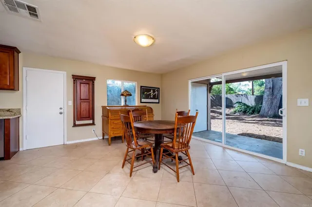 a view of a dining room with furniture and floor to ceiling window