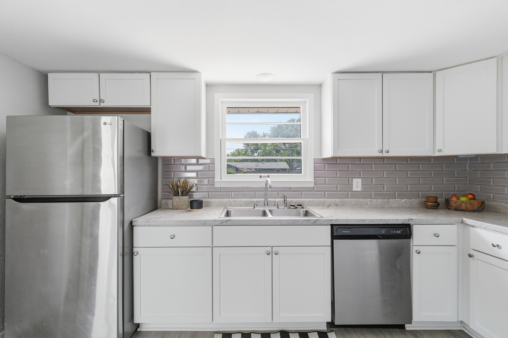 2306 9th Street Silvis, IL 61282 - Photo 15 of 32 a kitchen with a sink a refrigerator a window and cabinets