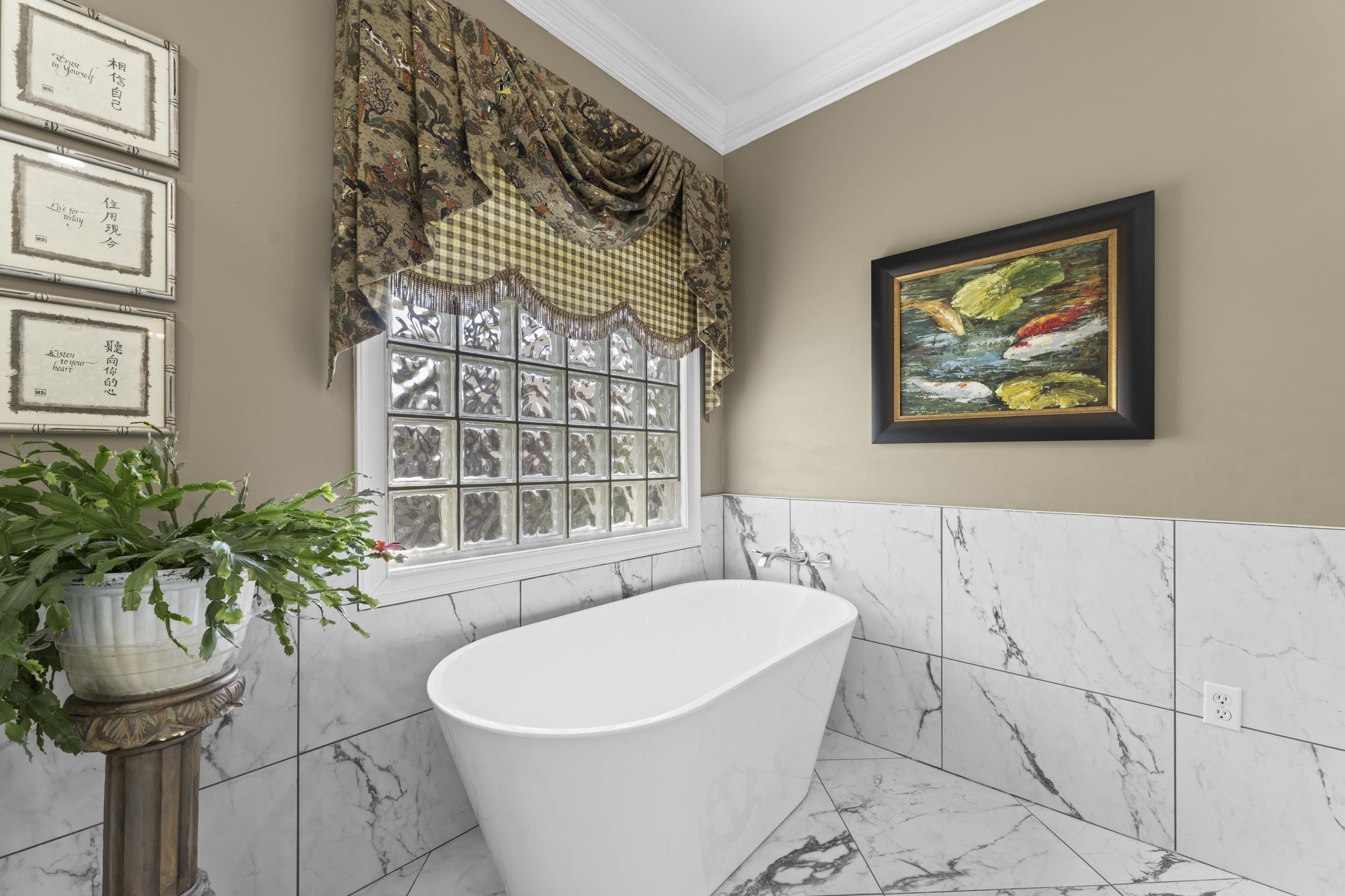 4132 Blackheath Drive Bartlett, TN 38135 - Photo 23 of 40 a white bath tub sitting in a bathroom next to a window