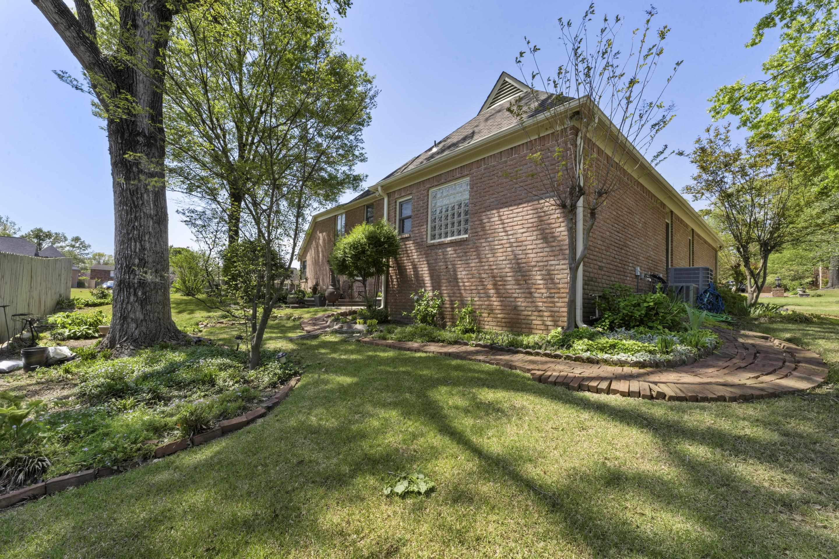 4132 Blackheath Drive Bartlett, TN 38135 - Photo 33 of 40 a backyard of a house with plants and large tree