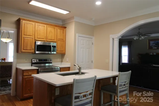 a kitchen with sink a refrigerator and wooden floor