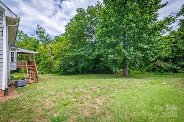 a house that has a bunch of plants and trees in the background