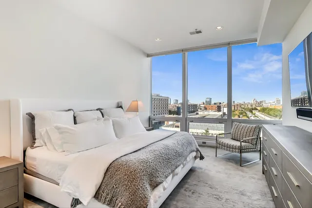 a bedroom with a bed and a large window