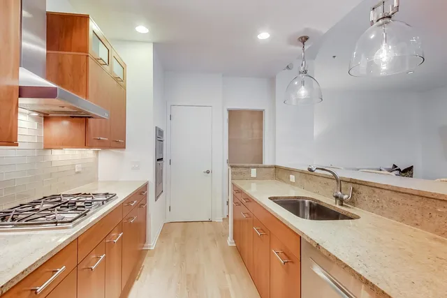 a kitchen that has a sink a stove and cabinets