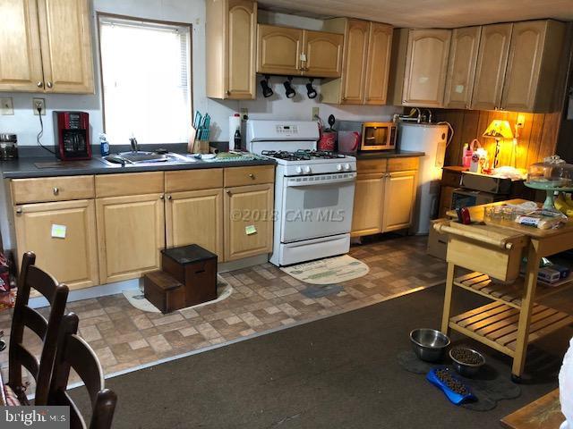 7713 Libertytown Road Berlin, MD 21811 - Photo 5 of 14 a kitchen with a sink a stove and cabinets