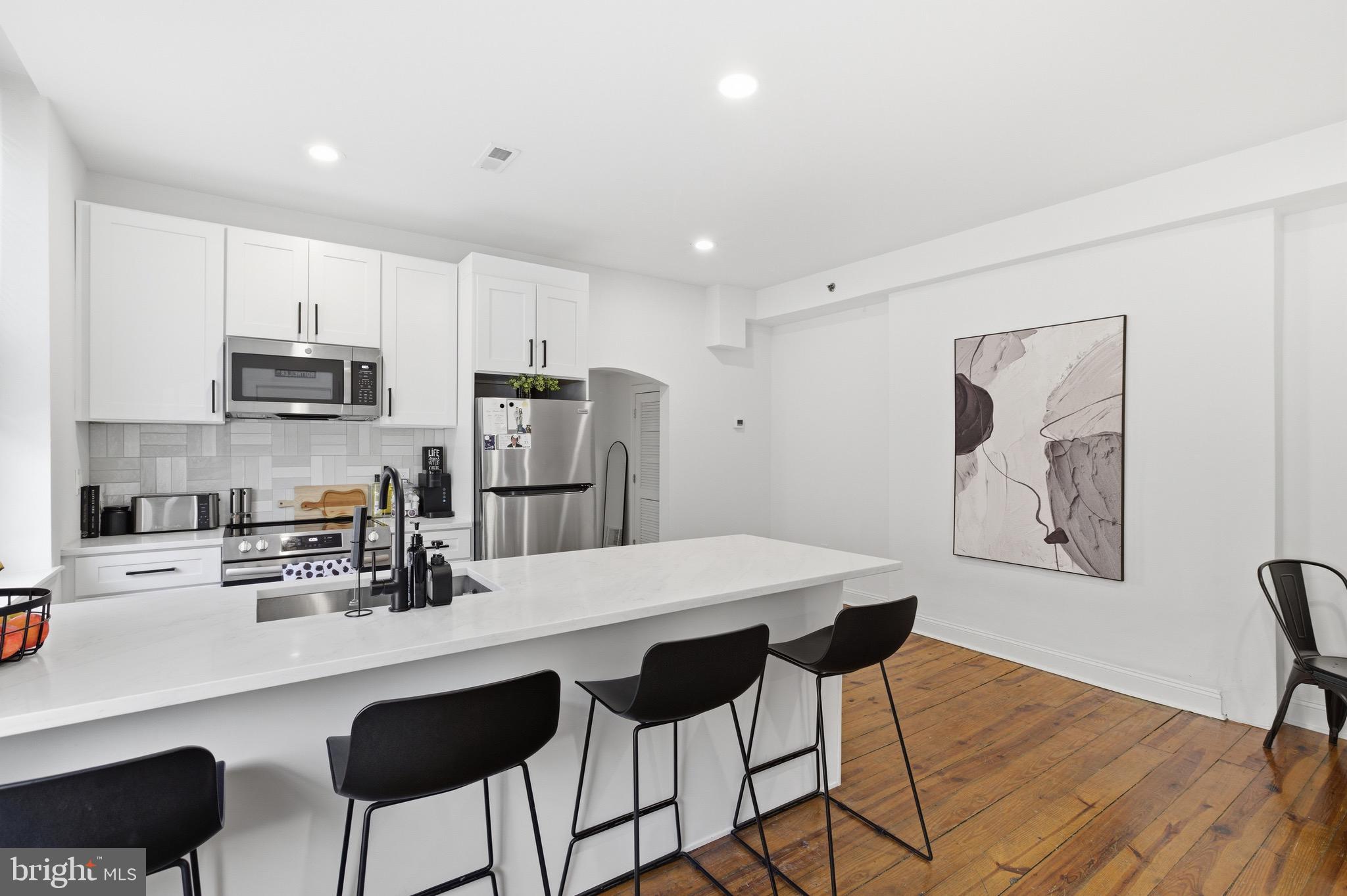 700 South 2nd Street, Unit B1 Philadelphia, PA 19147 - Photo 2 of 18 a kitchen with stainless steel appliances granite countertop a refrigerator a stove a sink dishwasher and white cabinets with wooden floor