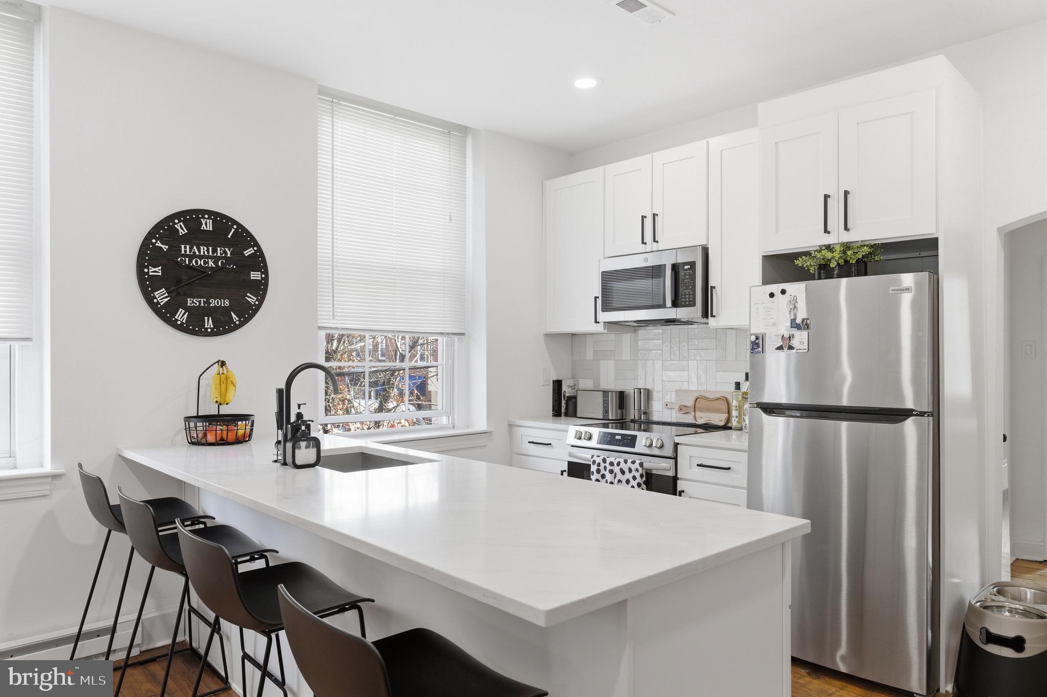 700 South 2nd Street, Unit B1 Philadelphia, PA 19147 - Photo 4 of 18 a kitchen with kitchen island a refrigerator a stove a sink and a refrigerator with wooden floor