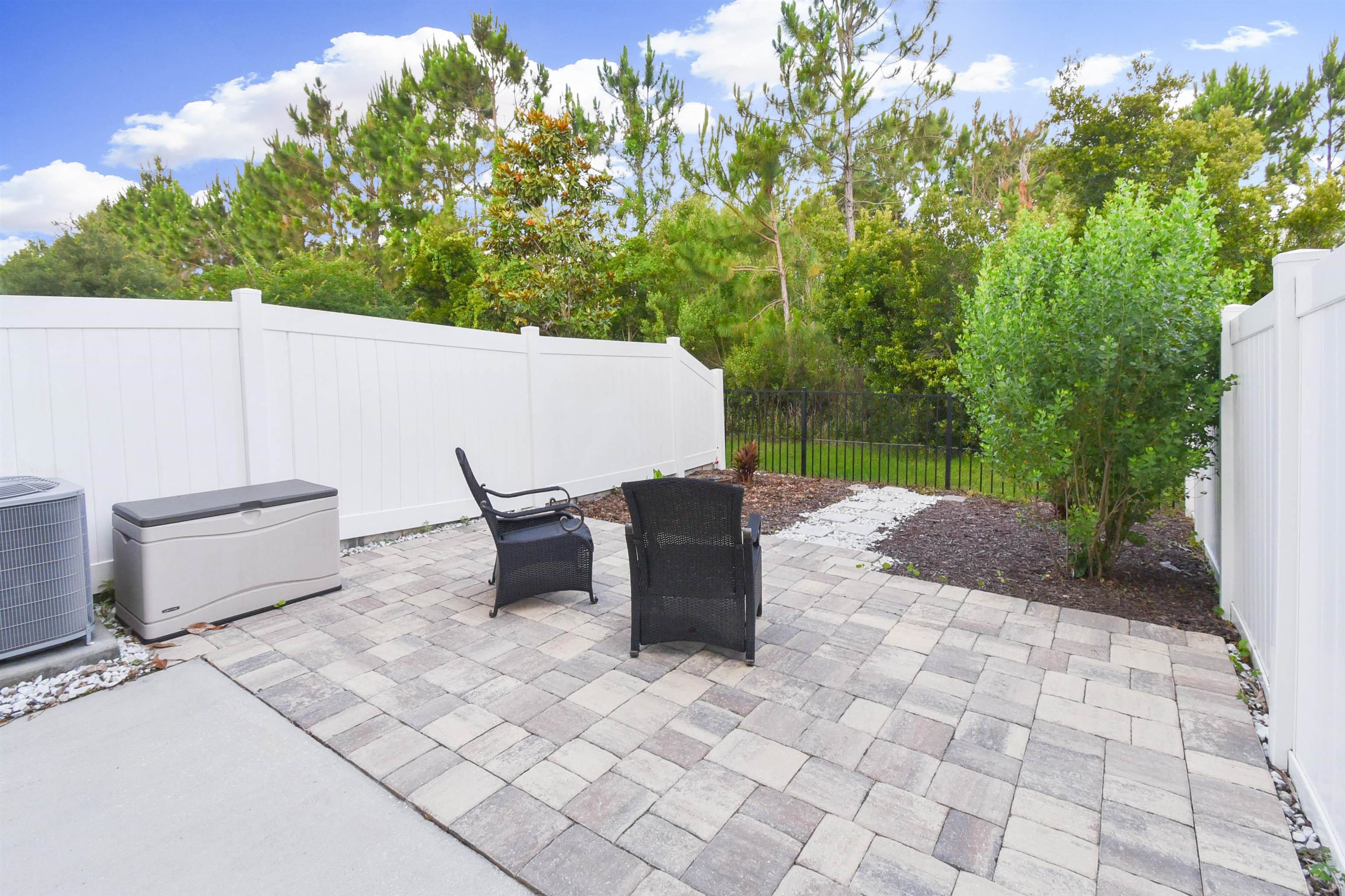105 Ridge Lake Road St. Augustine, FL 32086 - Photo 30 of 34 a view of a patio with table and chairs with wooden fence