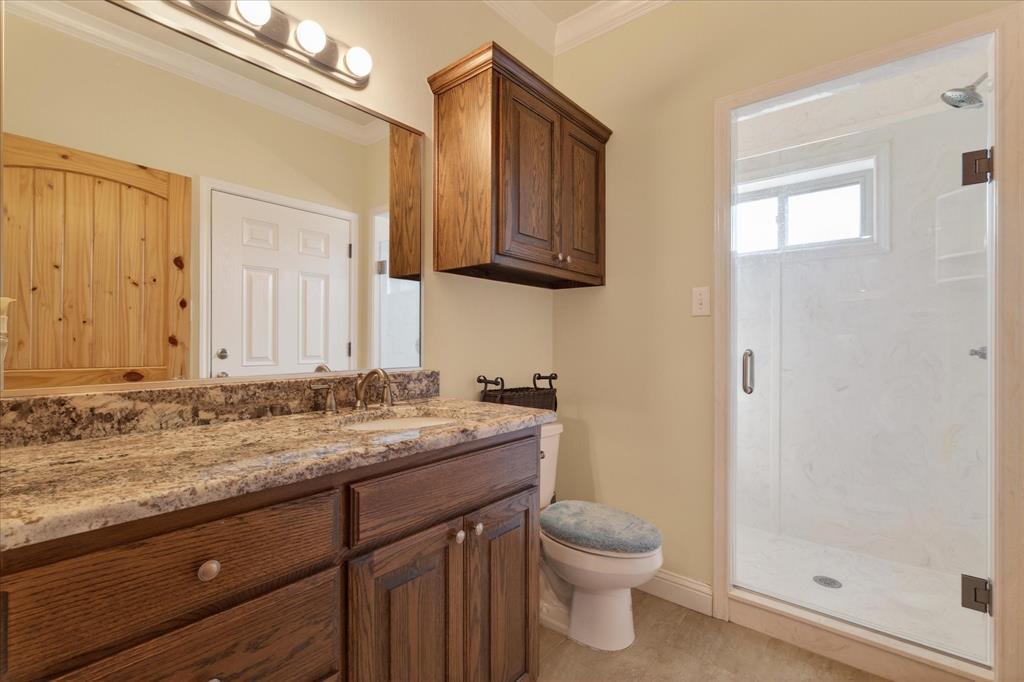 790 Bones Chapel Road Whitesboro, TX 76273 - Photo 35 of 39 a bathroom with a granite countertop sink toilet and shower