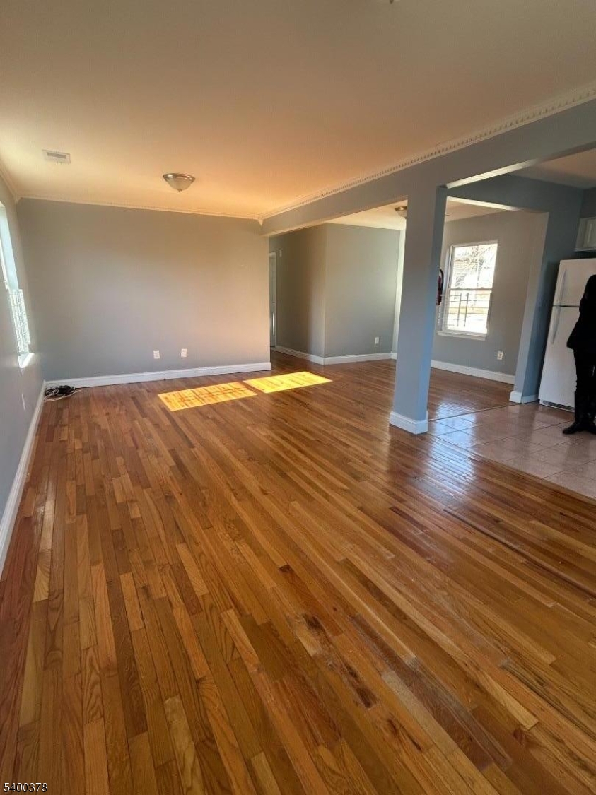 392 South 8th Street, Unit 2 Newark, NJ 07103 - Photo 2 of 6 a view of empty room with wooden floor and fan