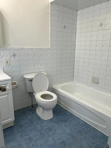 a white toilet sitting next to a bathtub