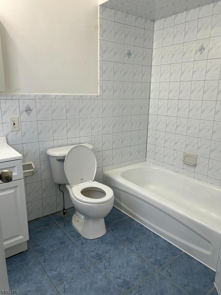 392 South 8th Street, Unit 2 Newark, NJ 07103 - Photo 5 of 6 a white toilet sitting next to a bathtub