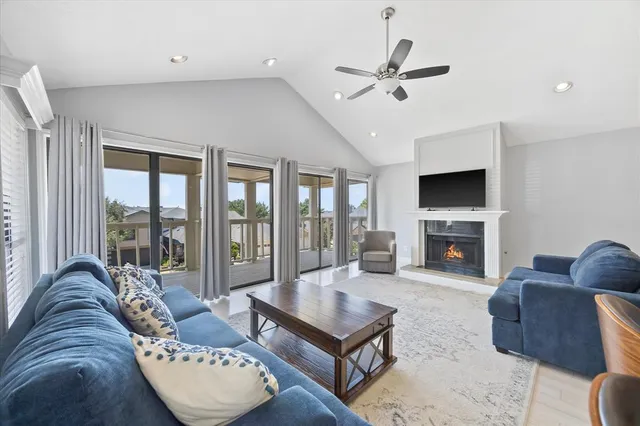 a living room with furniture a fireplace and a floor to ceiling window