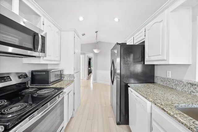 a kitchen with stainless steel appliances granite countertop a stove a refrigerator and a microwave