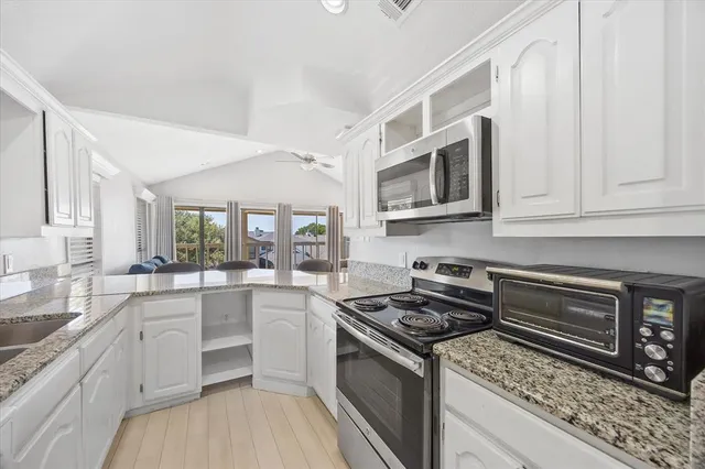 a kitchen with stainless steel appliances granite countertop a stove microwave and cabinets