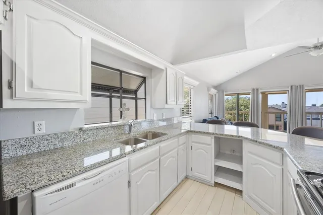 a kitchen with granite countertop a sink and cabinets