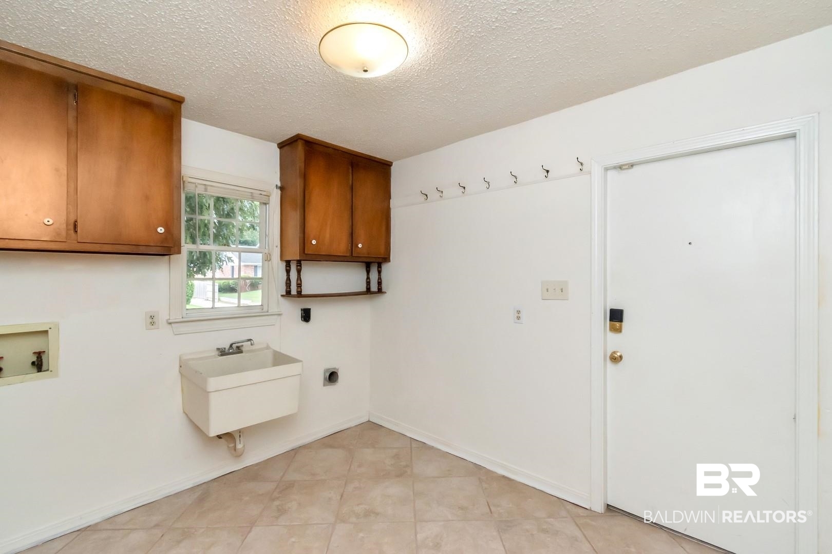 1229 West Chimney Top Drive Mobile, AL 36695 - Photo 35 of 36 Washroom with hookup for a washing machine, light tile patterned flooring, a textured ceiling, cabinets, and sink