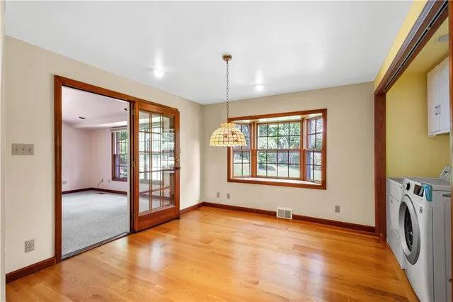 a view of an empty room with a window and a kitchen