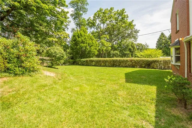 a view of yard with swimming pool and green space