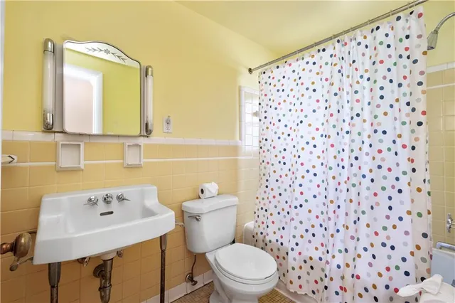 a bathroom with a sink a toilet and a mirror