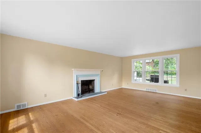 an empty room with a fireplace and windows