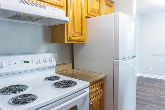 a kitchen with a refrigerator and a stove