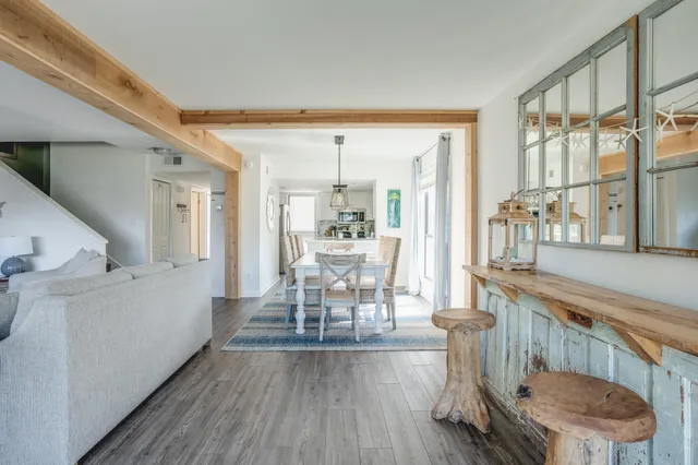 a dining room with furniture a chandelier and wooden floor