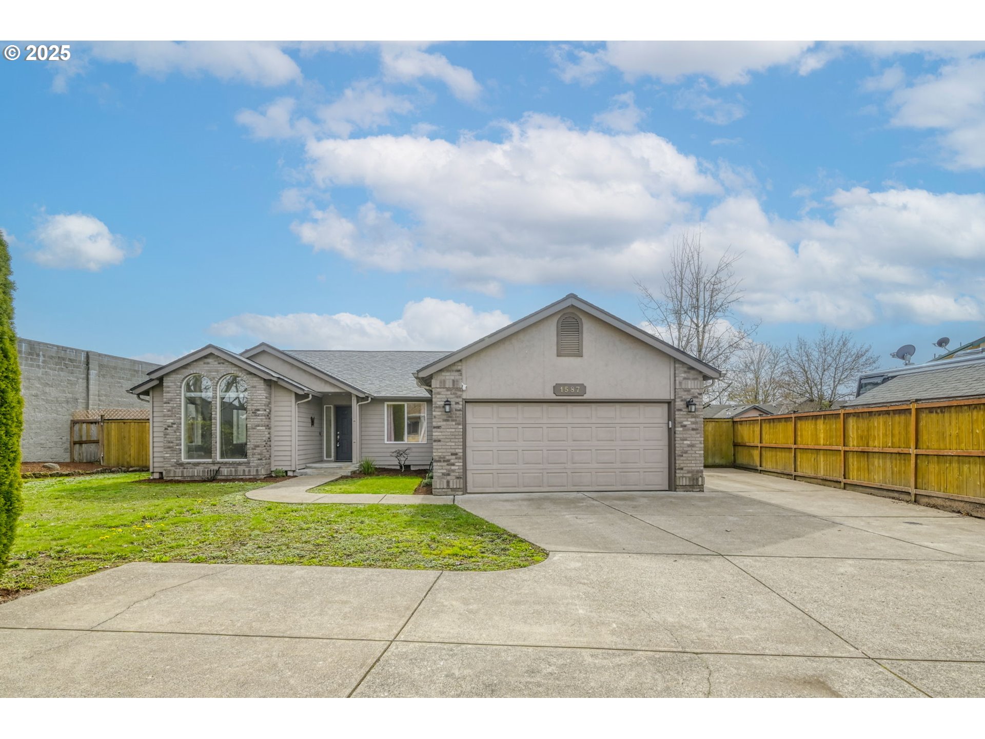 a view of a house with a big yard and large trees