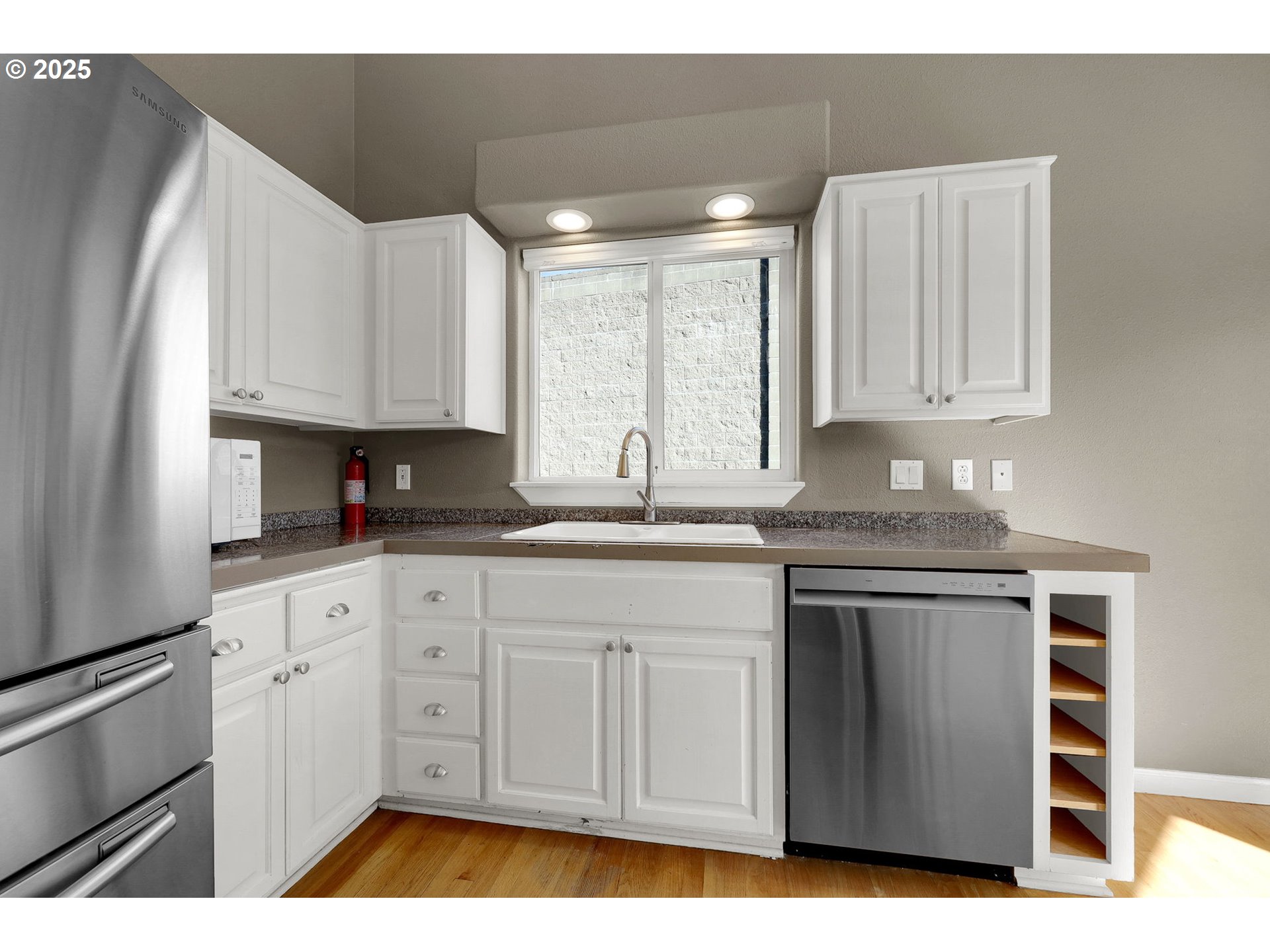 1587 Manchester Drive Eugene, OR 97401 - Photo 15 of 31 a kitchen with granite countertop white cabinets sink and stainless steel appliances
