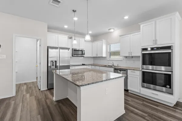 a kitchen with stainless steel appliances granite countertop a sink stove and refrigerator