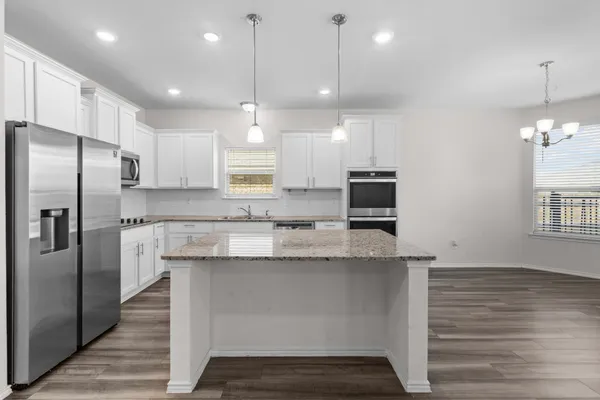 a kitchen with kitchen island a counter space a sink stainless steel appliances and cabinets