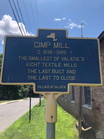 a wooden sign broad in front of building