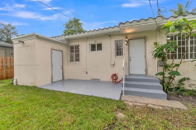 a view of a house with backyard and a garden