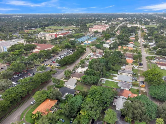 an aerial view of residential houses with outdoor space and trees
