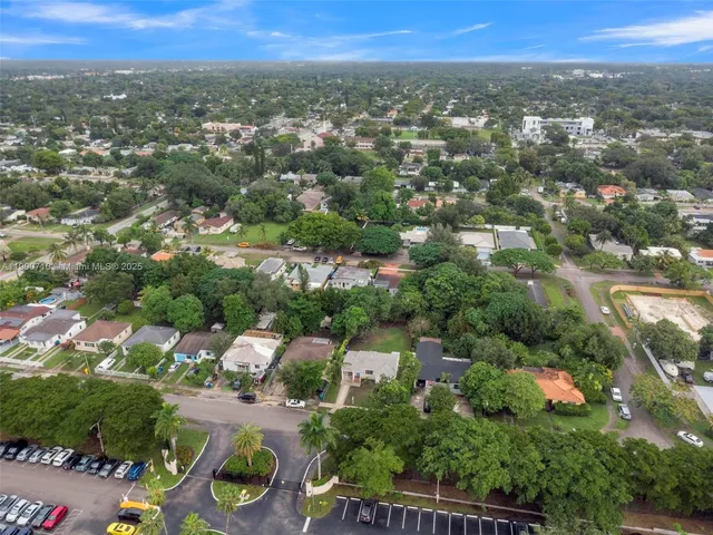 an aerial view of residential houses with outdoor space and trees