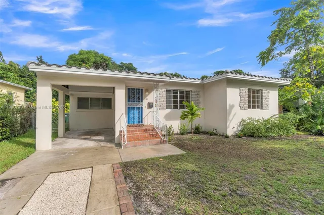 a view of a house with backyard and sitting area