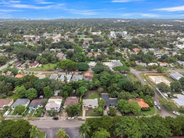 an aerial view of residential houses with outdoor space and trees