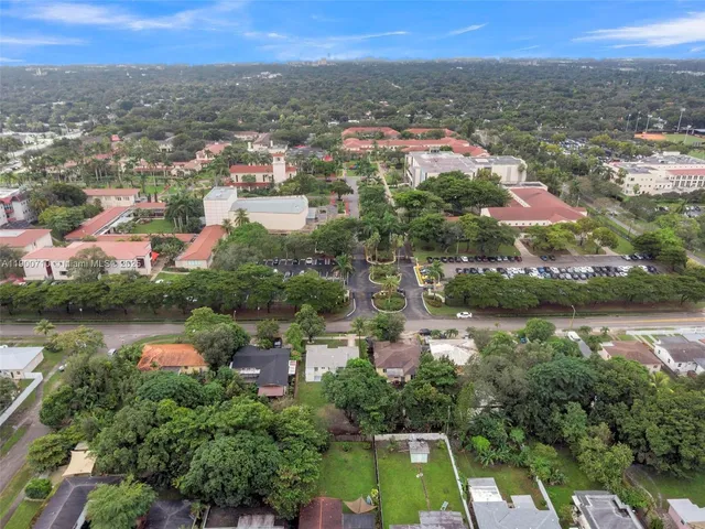 an aerial view of residential houses with outdoor space and lake view