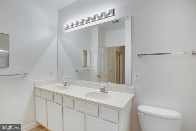 a bathroom with a sink a toilet and a mirror