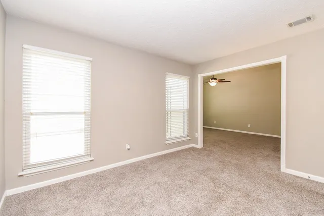 an empty room with windows and closet
