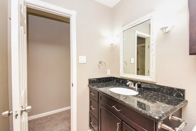 a bathroom with a granite countertop sink and a mirror